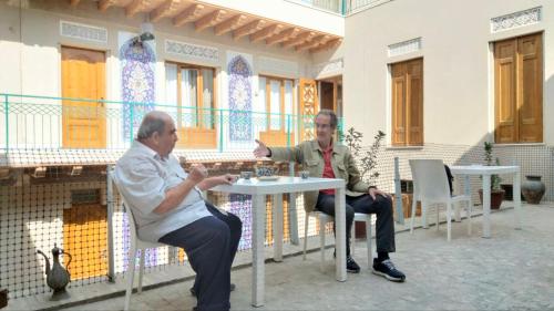 two men sitting at a table in a building at Mahbubakhon Guest house in old city in Bukhara