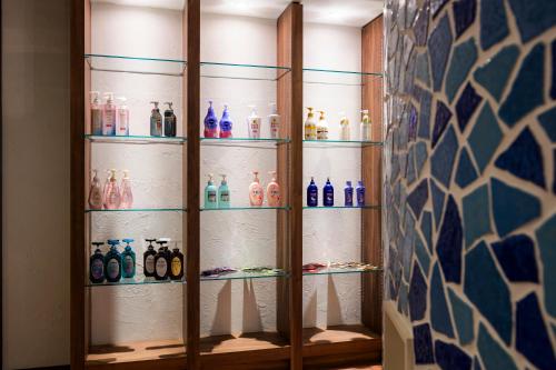 a glass cabinet filled with different colored bottles at ハッピーキス双葉店 in Kai