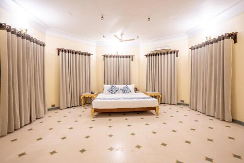 a bedroom with a bed and curtains at JuSTa Alwarbagh Sariska in Alwar