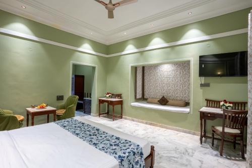 a bedroom with a bed and two tables and a window at JuSTa Alwarbagh Sariska in Alwar