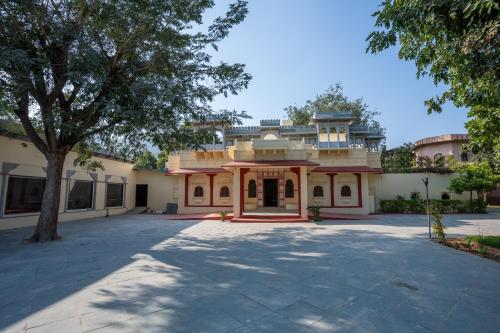a large building with a tree in front of it at JuSTa Alwarbagh Sariska in Alwar