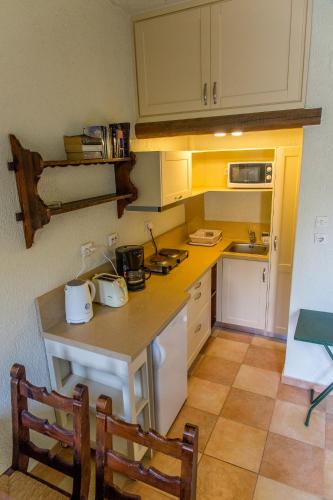 a small kitchen with a counter and chairs in it at Porto Sisi Hotel Apartments in Sissi