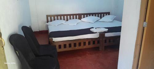 a bedroom with a bed with pillows and a chair at Pure Land Villa in Nallathaniya