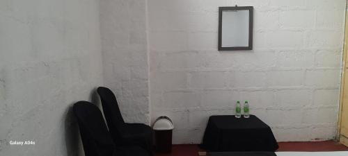 a room with a table and chairs and a mirror at Pure Land Villa in Nallathaniya
