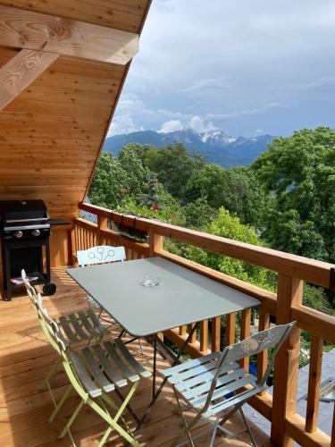 une table et des chaises sur le pont d'une cabine dans l'établissement Appartement entre lac & montagne, à Puy-Sanières
