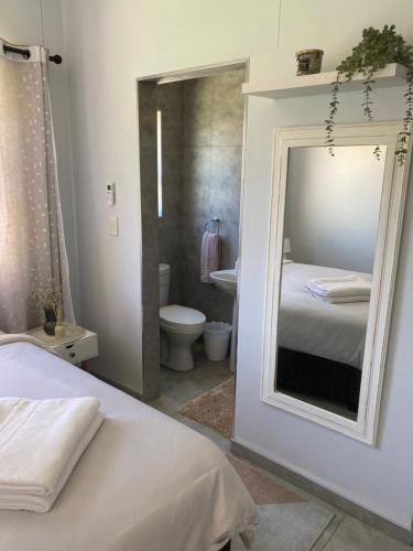 a bedroom with a mirror and a bathroom with a toilet at Sunbird self-catering B in Windhoek
