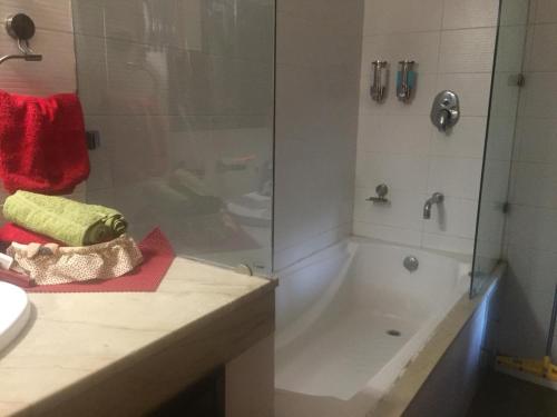 ein Badezimmer mit Dusche, Badewanne und Waschbecken in der Unterkunft STUDIO APARTMENT - TARUDHAN VALLEY GOLF RESORT Gurgaon in Gurgaon