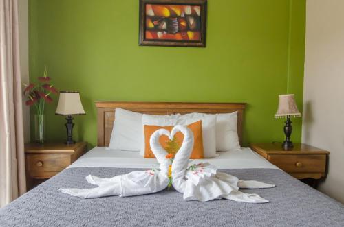 a bedroom with two swans made out of towels on a bed at Hotel La Casa de la Abuela in Boquete