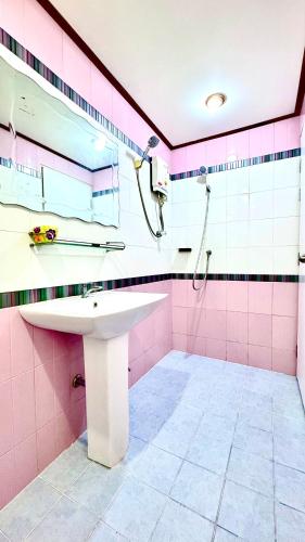 a pink bathroom with a sink and a shower at EZ House in Sukhothai