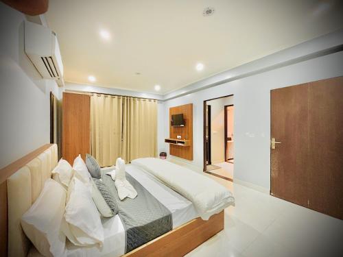 a bedroom with a large bed with white sheets and pillows at Hotel Grand Aana Inn in Jaipur