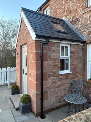 a solar roof on a brick house with a table at Croft View in Hayton