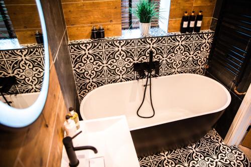 a bath tub in a bathroom with black and white tiles at Croft View in Hayton