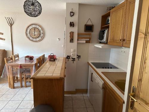 une cuisine avec une table et une cuisine avec une salle à manger dans l'établissement Le Génépi, à Les Deux Alpes