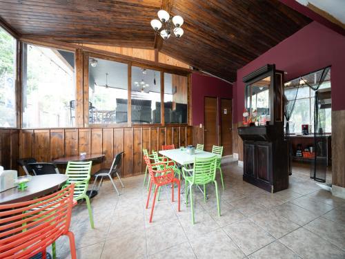 a restaurant with tables and chairs and a fireplace at Hotel La Casa de la Abuela in Boquete