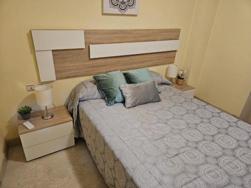 a bedroom with a large bed with two pillows at Carnaval 16 in Isla Cristina