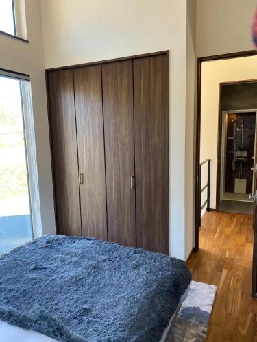 a bedroom with a large wooden cabinet and a bed at Niseko Forest Avenue 63 in Niseko