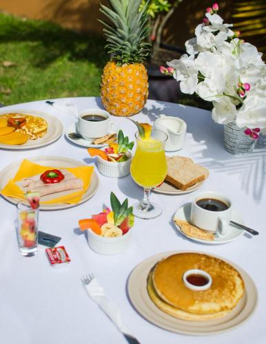 a white table topped with plates of food and a pineapple at Hotel La Casa de la Abuela in Boquete