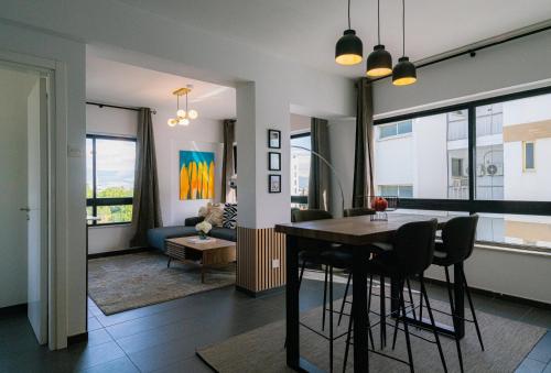 a dining room and living room with a table and chairs at Element Stays City Suite in Nicosia