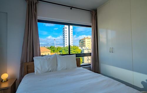 a bedroom with a bed and a large window at Element Stays City Suite in Nicosia