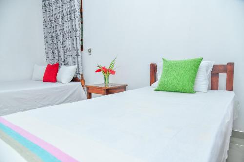 two beds with colorful pillows in a room at Turtle cove residence in Tangalle