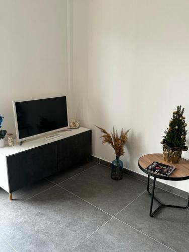 a living room with a flat screen tv and a table at Blue Orchid Apartment, IUN S8460 in Quartu SantʼElena
