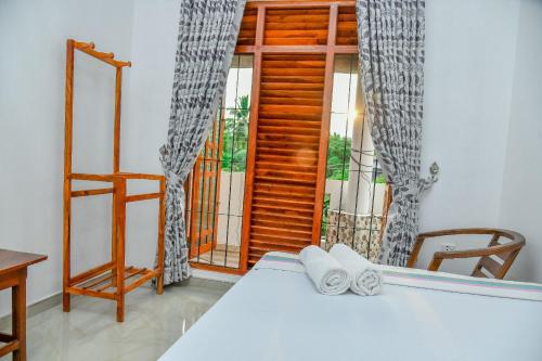 a bedroom with a bed and a window and a table at Turtle cove residence in Tangalle