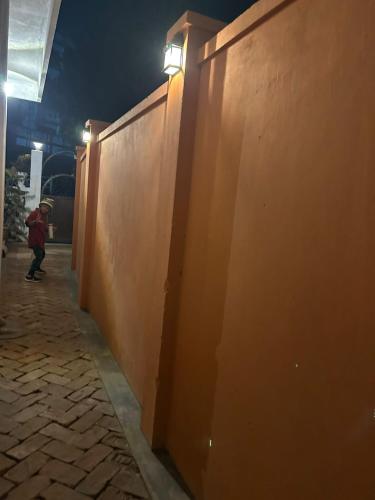 a person riding a skateboard next to a wall at night at Apple Cherry Pine Green Homestay in Shillong