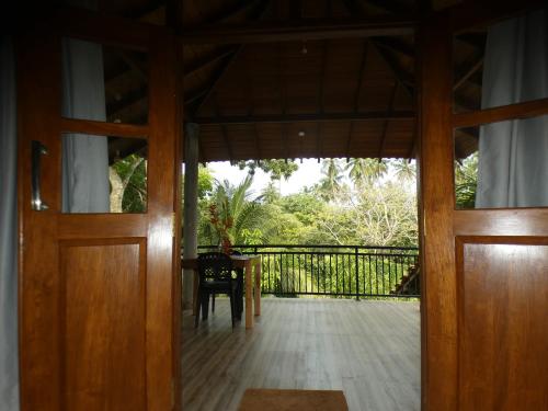 an open door to a balcony with a table and chairs at Lisha Mawella in Tangalle