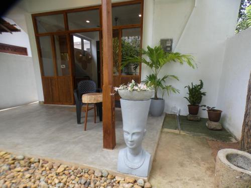 a statue of a head with a planter on a patio at Lisha Mawella in Tangalle
