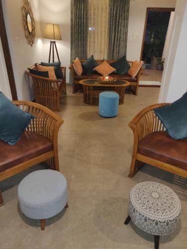 a living room with couches and a table at The Elegant homes in Kushālnagar