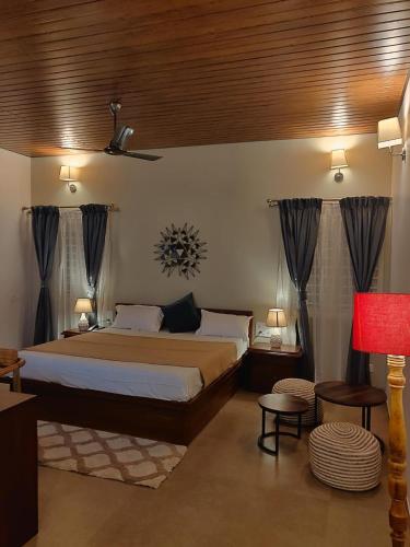 a bedroom with a large bed with a wooden ceiling at The Elegant homes in Kushālnagar