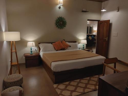 a bedroom with a bed with two lamps and a mirror at The Elegant homes in Kushālnagar