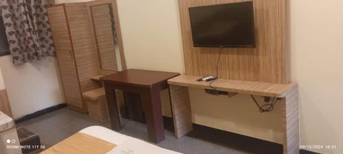 a room with a desk and a tv on a wall at Hotel nav bharath residency in Hyderabad