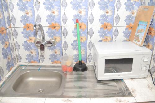 een gootsteen met een magnetron en een drankje bij Afrika Nomades in Abidjan