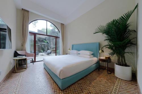 a bedroom with a bed and a potted plant at Linggan Linghai Hotel in Xiamen