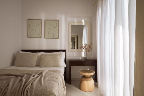 a bedroom with a bed and a table and a mirror at Kalas SeaView Residence, a Serene Sanctuary, By ThinkVilla in Zakynthos Town