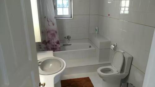 a white bathroom with a toilet and a sink at Villa Maira 2, Amazing Family apartment, 3 bedrooms, Swimming Pool, 150m to beach in Perea