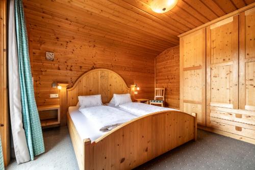 a bedroom with a large bed in a wooden room at Gsenghof in Filzmoos