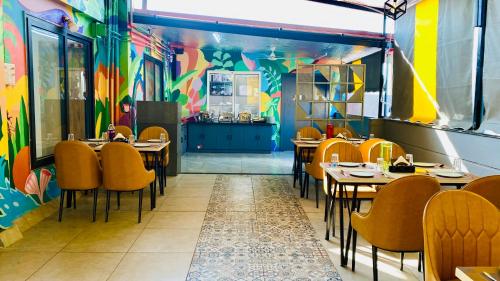 a restaurant with tables and chairs and a colorful wall at The Shankara View in Godarpura