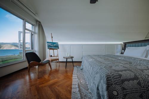 a bedroom with a bed and a view of the ocean at Lakeside Retreat - LuguLake Lijiang in Zuosuo