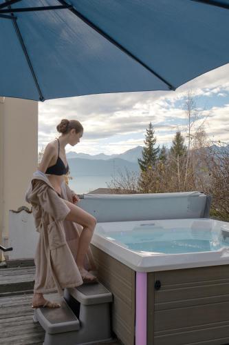 a woman sitting on the edge of a bath tub at Villa Orso Grigio in Ronzone