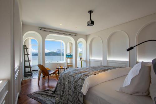 a bedroom with a bed with a view of the water at Lakeside Retreat - LuguLake Lijiang in Zuosuo