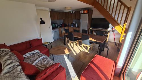 un salon avec un canapé rouge et une table dans l'établissement Appartement duplex T3, Isola2000, France, à Isola 2000