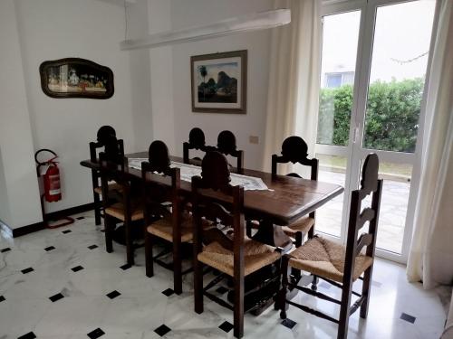 a dining room with a wooden table and chairs at Casa Rosella in Albenga