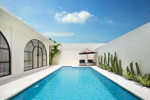 an infinity pool in a house with cactus at The Grand Daha Luxury Villas in Seminyak