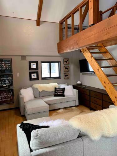 a living room with a couch and a staircase at Casa Bell Cabin Niseko in Niseko