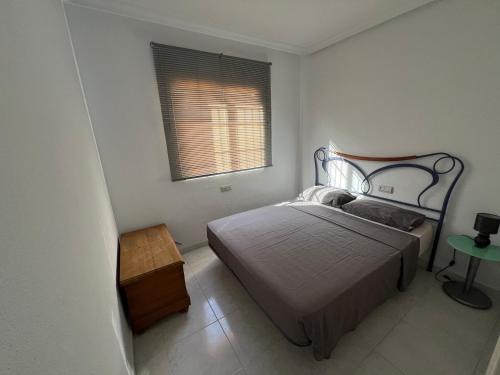a small bedroom with a bed and a window at Chalet La Mata in Torrevieja