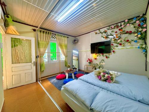 a bedroom with a bed with flowers on the wall at Rose's House in Da Lat
