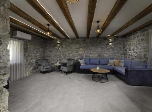 un salon avec un canapé bleu et des chaises dans l'établissement Luxury Krk Villa with Private Pool and Gardens, à Krk