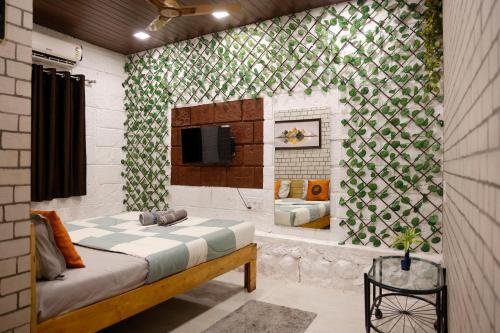 une chambre avec un lit et une télévision sur un mur dans l'établissement Hashtag Travellers By Mody Stays, à Lonavala